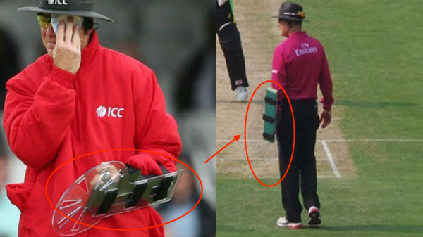What is umpire Bruce Oxenford wearing on his arm? Why does he wear it?